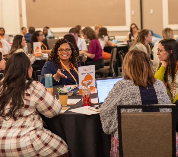A group of early childhood professionals sitting at a table talking at an professional development event