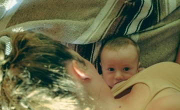 A mother and infant lying on a blanket