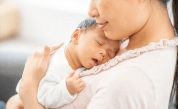 mom holds sleeping baby on her chese
